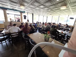 A crowded view of the restaurant, capturing the lively atmosphere at Com Tam Dat Thanh, with several groups of people enjoying their meals.