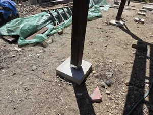 Close-up of wood post secured to concrete base